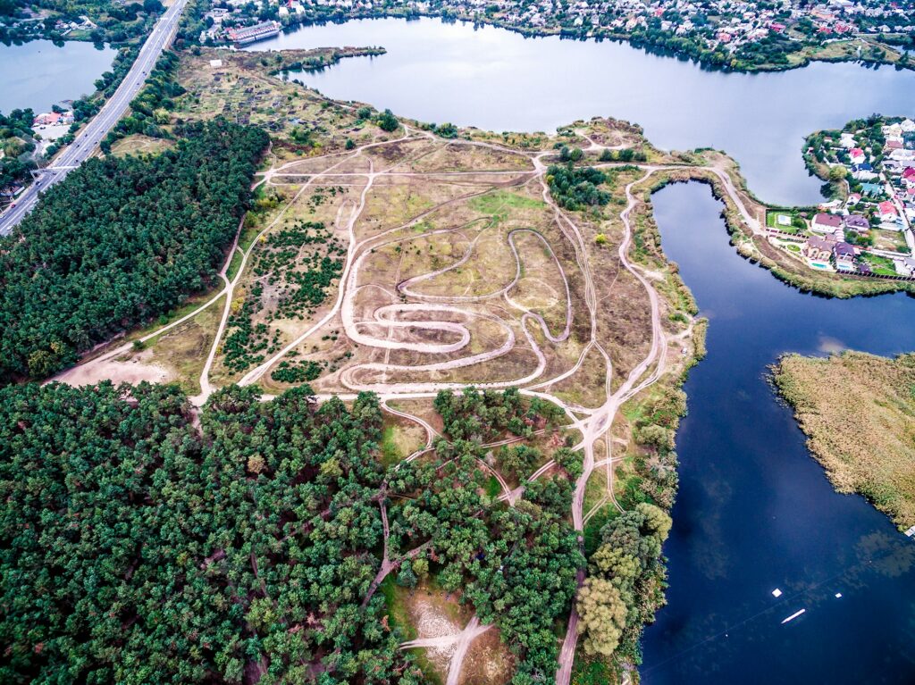 colorful suburb with grove and tracks surrounded by water